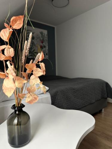 a black vase with flowers on a table in a bedroom at Boutique Hotel VIVA CREATIVO in Hannover