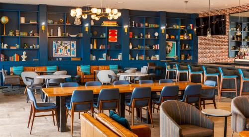 a restaurant with blue walls and tables and chairs at Canopy By Hilton Dallas Uptown in Dallas