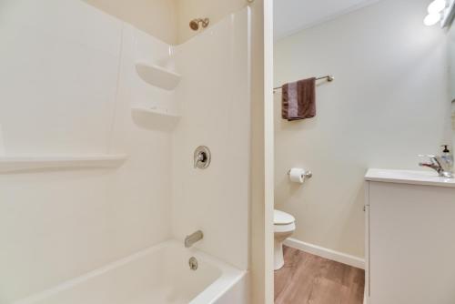 a white bathroom with a tub and a toilet at Point Breeze Vacation Rental, Walk to Lake Ontario in Waterport