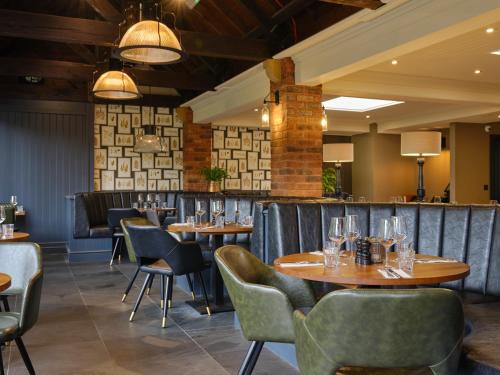 a restaurant with tables and chairs and a bar at The Kingfisher in Bedford