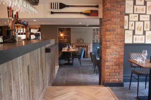 a bar in a restaurant with tables and chairs at The Kingfisher in Bedford