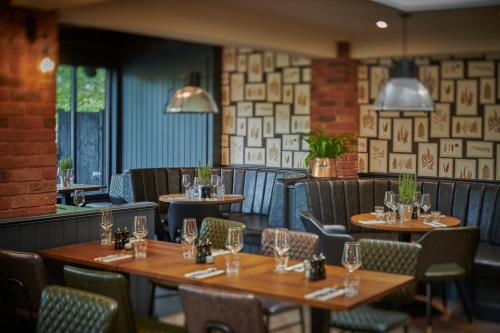 a dining room with wooden tables and chairs at The Kingfisher in Bedford