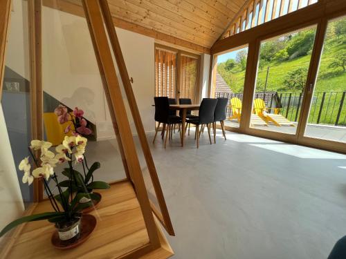 a room with a table and chairs and a large window at MARYS family friendly Apartments,VISIT RHINE FALLS for FREE if you stay 2 nights, SOHO 95m2 2-Bedrooms 2nd floor & SOUTH BEACH 105m2 3-Bedrooms & LOFT 115m2 3-Bedrooms Suite with Galerie,LOFT Netz 20m2, Pinball, Schaffhausen-Hemmental, Rheinfall 10 km in Schaffhausen
