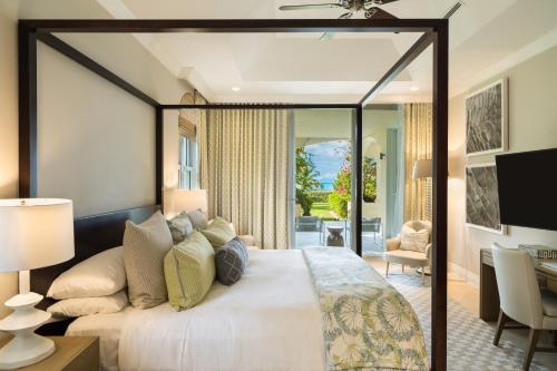 a bedroom with a large bed and a desk at Grace Bay Club in Grace Bay