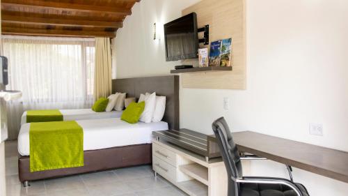 a hotel room with a bed and a desk and a computer at Hotel San Juan Internacional in Bucaramanga