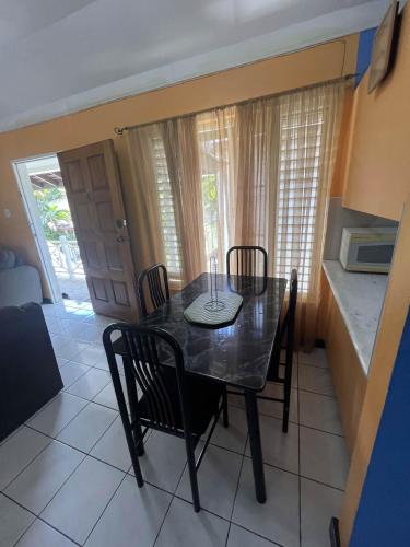 a dining room with a black table and chairs at Finest Accommodation Renfrew Place 1 Bedroom Apt # 42 New Kgn 4--12 Renfrew Rd in Kingston