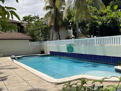 a large blue swimming pool with a white fence at Finest Accommodation Renfrew Place 1 Bedroom Apt # 42 New Kgn 4--12 Renfrew Rd in Kingston