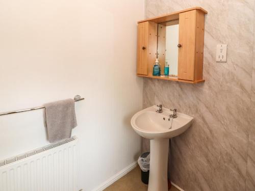 W łazience znajduje się umywalka i lustro. w obiekcie Langdale Lodge 15 w mieście Windermere
