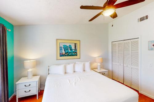 a bedroom with a white bed and two night stands at Gulf Highlands - 238 Saint Katherine in Panama City Beach