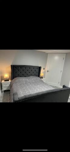 a bed in a bedroom with two lamps on tables at The Captains Wheel and Anchor in Skerries