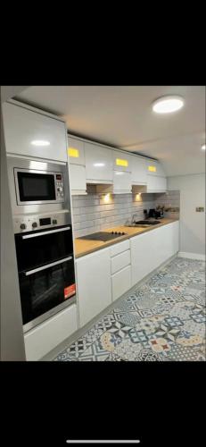 a kitchen with white cabinets and an oven at The Captains Wheel and Anchor in Skerries