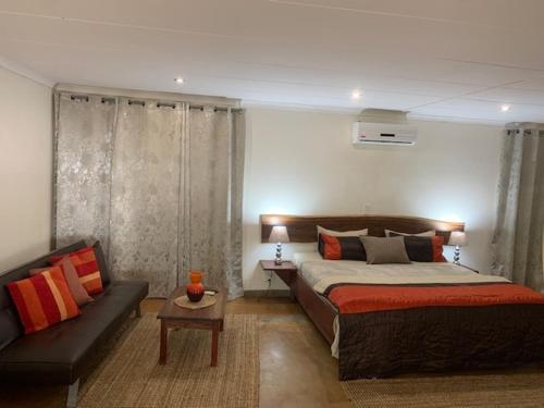 um quarto com uma cama e um sofá em R A GUEST HOUSE PEMBA em Pemba