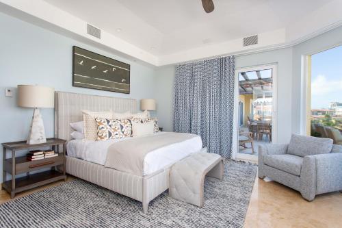 a bedroom with a bed and a chair and a window at Grace Bay Club in Grace Bay