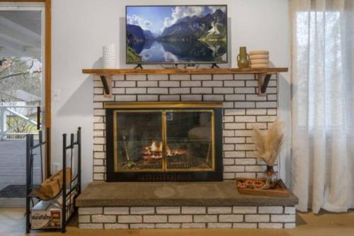 a brick fireplace with a tv on top of it at Cayuga bungalow on lake—sleeps 13—outdoor firepit in Lansing