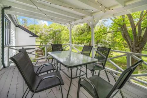 a patio with a table and chairs on a deck at Cayuga bungalow on lake—sleeps 13—outdoor firepit in Lansing