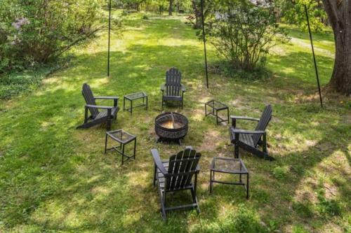 a group of chairs and a fire pit in the grass at Cayuga bungalow on lake—sleeps 13—outdoor firepit in Lansing