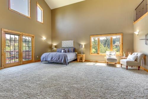 a bedroom with a bed and a chair and windows at Mountain-View Rental with Hot Tub - 9 Mi to Helena! in Clancy