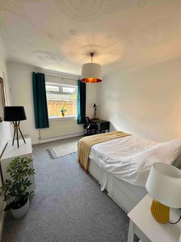 Un dormitorio con una cama grande y una ventana en Spindrift, Spacious bungalow near beach, en Hamworthy