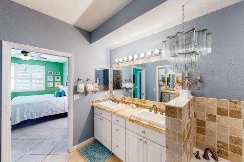 łazienka z umywalką, łóżkiem i lustrem w obiekcie Tarpon Watch w mieście Key West