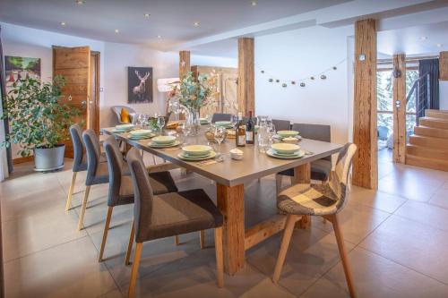 a dining room with a wooden table and chairs at Chalet Pativerdan - OVO Network in Samoëns