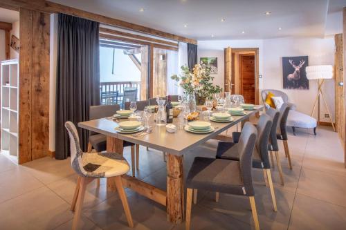 a dining room with a large wooden table and chairs at Chalet Pativerdan - OVO Network in Samoëns