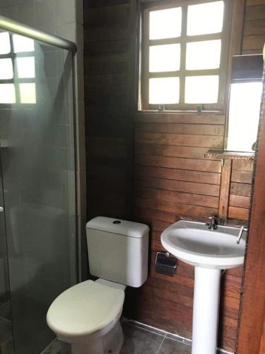 a bathroom with a toilet and a sink at Chalé Primavera in Juquitiba