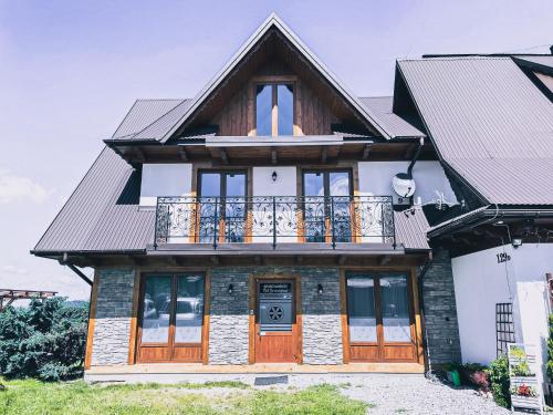 a house with a balcony on top of it at Apartamenty Pod Brzezinami in Murzasichle