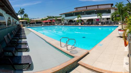 uma grande piscina com cadeiras e um edifício em Hotel San Juan Internacional em Bucaramanga