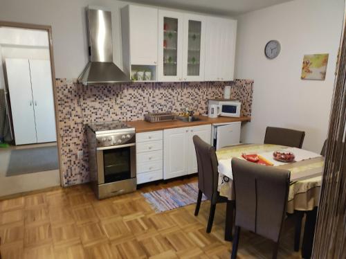 a kitchen with a table and a dining room at Studio apartman Vuković 4 zvjezdice in Bizovac