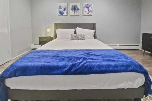 a large bed with a blue blanket on top of it at Bright 2BR Apartment in Stamford in Stamford