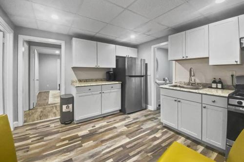 a kitchen with white cabinets and a wooden floor at Bright 2BR Apartment in Stamford in Stamford