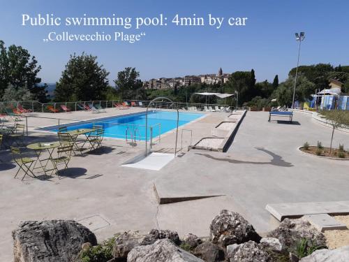 una piscina en un parque con rocas en el primer plano en Casa romantica in un borgo antico in Sabina, en Cicignano