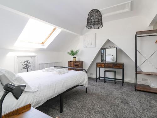 um quarto com uma cama, uma secretária e um espelho em 18 Ffordd Tanrallt em Prestatyn