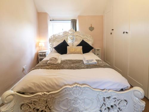 a bedroom with a large bed with a white headboard at Primrose Cottage Stow in Stow on the Wold