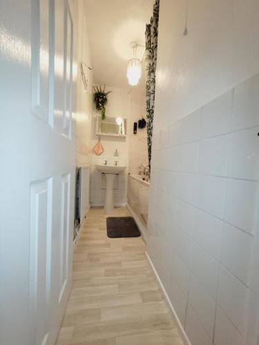 um corredor com uma casa de banho branca com um lavatório em EXCELLENT DOUBLE ROOMS IN CHEAP RATE AROUND CENTRAL LONDON em Londres