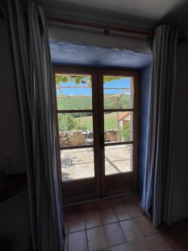 a door with a window with a view of a field at Mas Lo Faix in Saint-Laurent-de-Cerdans