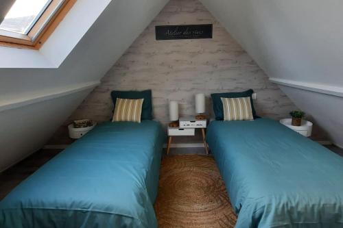 2 camas en un ático con almohadas verdes en Gîte Terres d'Opale, en Nesles