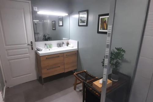 baño con lavabo, espejo y silla en Gîte Terres d'Opale, en Nesles