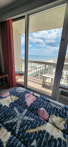 a bedroom with a bed and a view of the ocean at Oceanview Studio in Daytona Beach