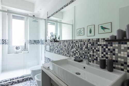 ミラノにあるSan Siro Apartmentのバスルーム(洗面台、トイレ、鏡付)