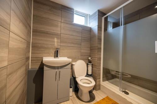 a bathroom with a toilet and a sink and a shower at Pristine 3 bed Apartment in London