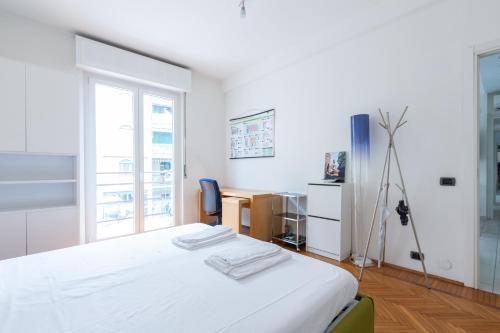 Habitación blanca con cama y ventana en San Siro Apartment, en Milán