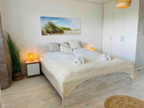 a bedroom with a large bed with two stuffed animals on it at Düne 77 Moderne Ferienwohnung in Baltrum