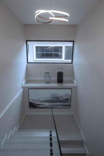 a staircase with a window and a glass table at Knightsbridge Hotel & Suites in Abuja