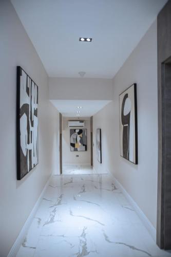 a white room with black and white art on the walls at Knightsbridge Hotel & Suites in Abuja