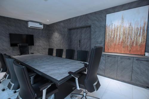 a conference room with a large table and chairs at Knightsbridge Hotel & Suites in Abuja