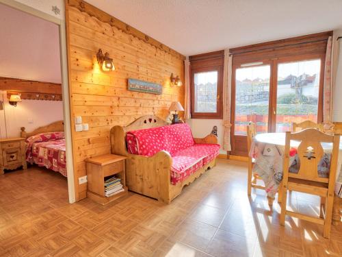 a bedroom with a bed and a wooden wall at Appartement Flumet, 3 pièces, 6 personnes - FR-1-505-13 in Flumet