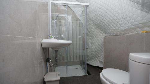 uma casa de banho com um chuveiro, um lavatório e um WC. em Tiris Pisan Glamping & Resort Puncak em Cikuray
