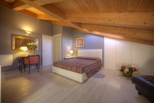 Un dormitorio con una cama y una mesa en una habitación. en Holidays alle rose, en Peschiera del Garda