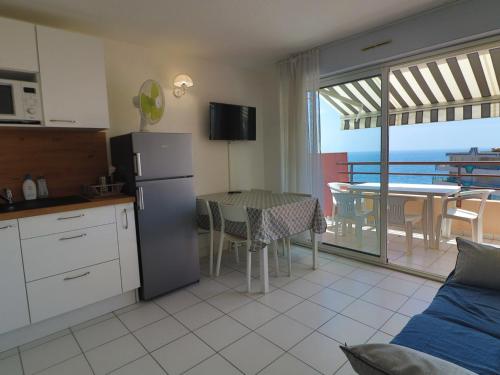 - une cuisine et une salle à manger avec une table et une vue sur l'océan dans l'établissement 2 pièces cabine, WIFI, terrasse 6m², dernier étage à Sète - FR-1-472A-230, à Sète
